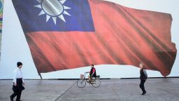 People walk past a Taiwanese flag in New Taipei City.