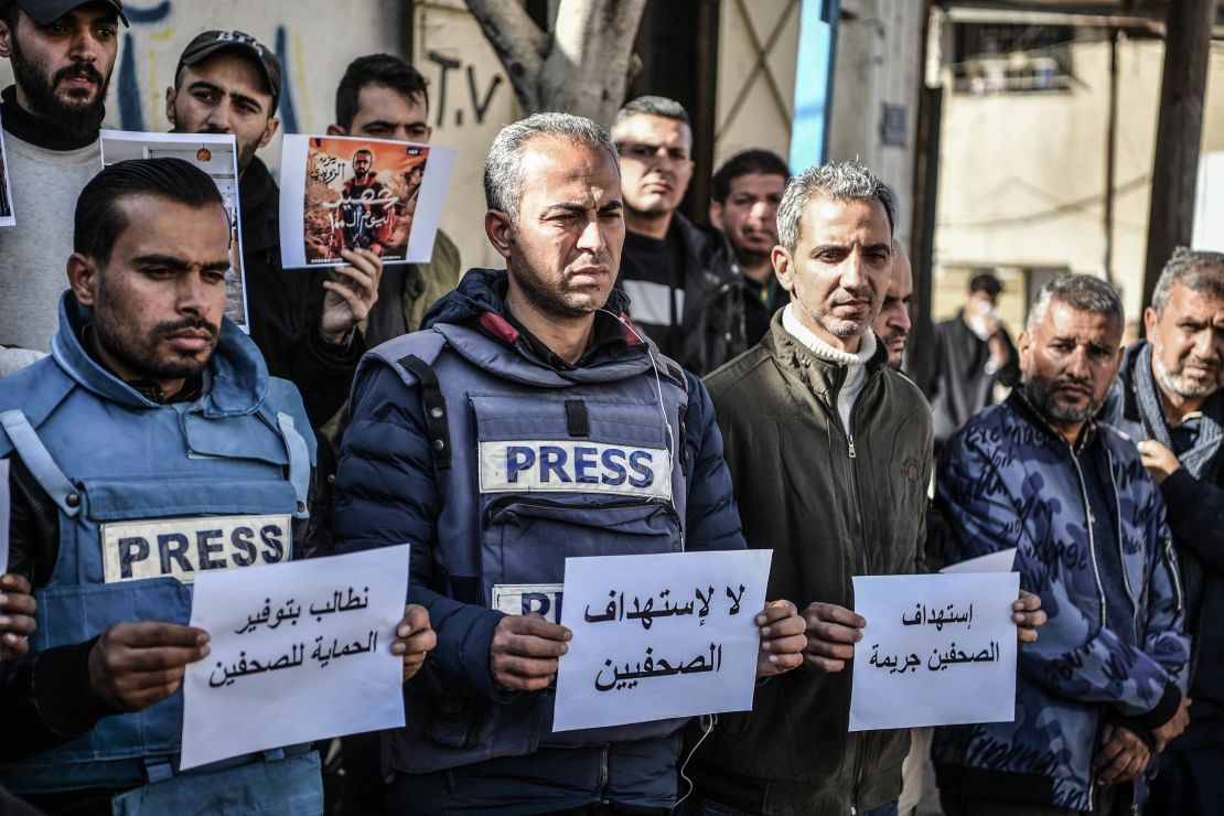 Members of the press, who try to perform their duties in the Gaza Strip, carry banners reading 'the press is free and cannot be silenced.'