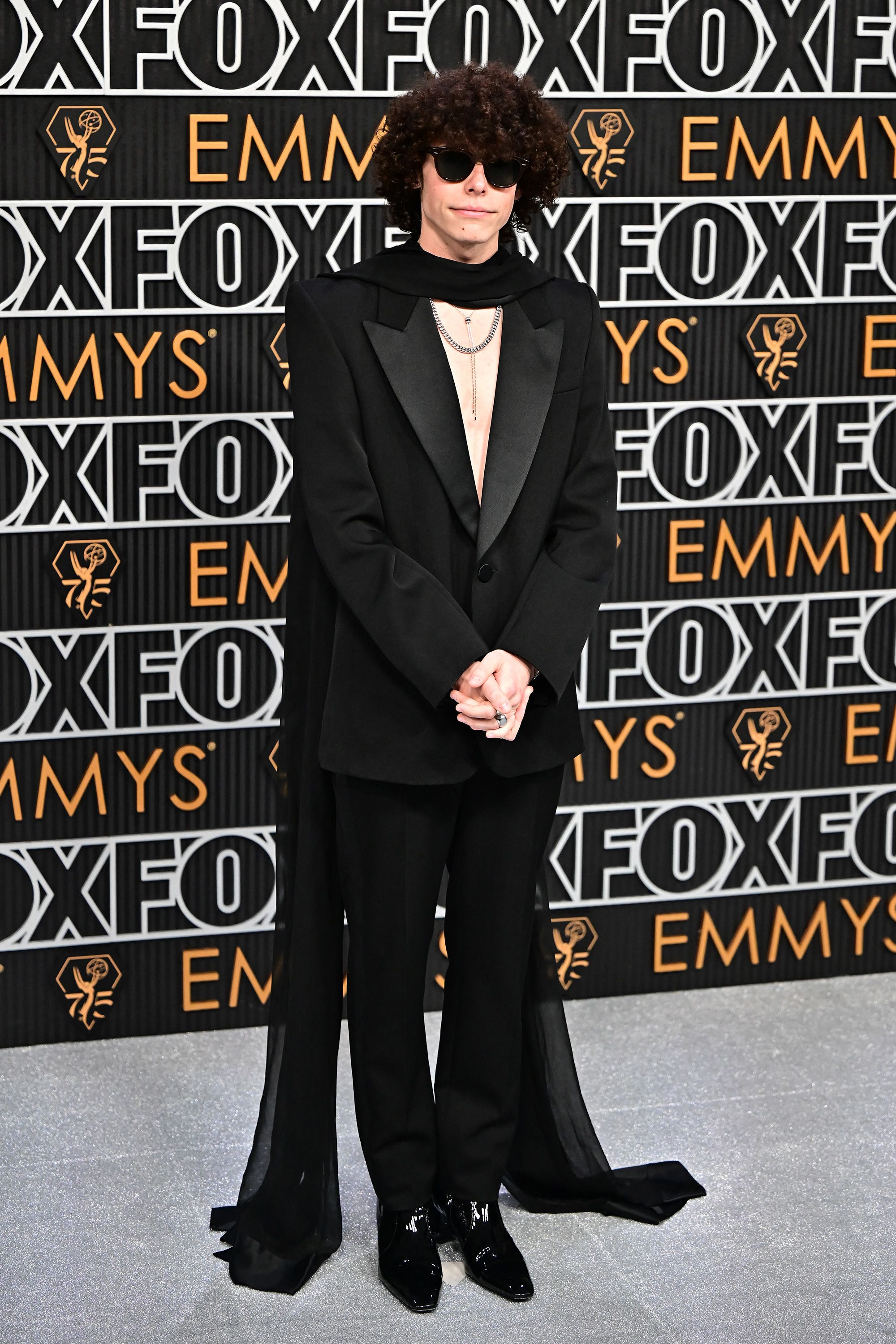 Channeling a little rock glam, actor Reece Feldman opted to go shirtless in a Saint Laurent tuxedo, trailing black scarf and silver jewelry.