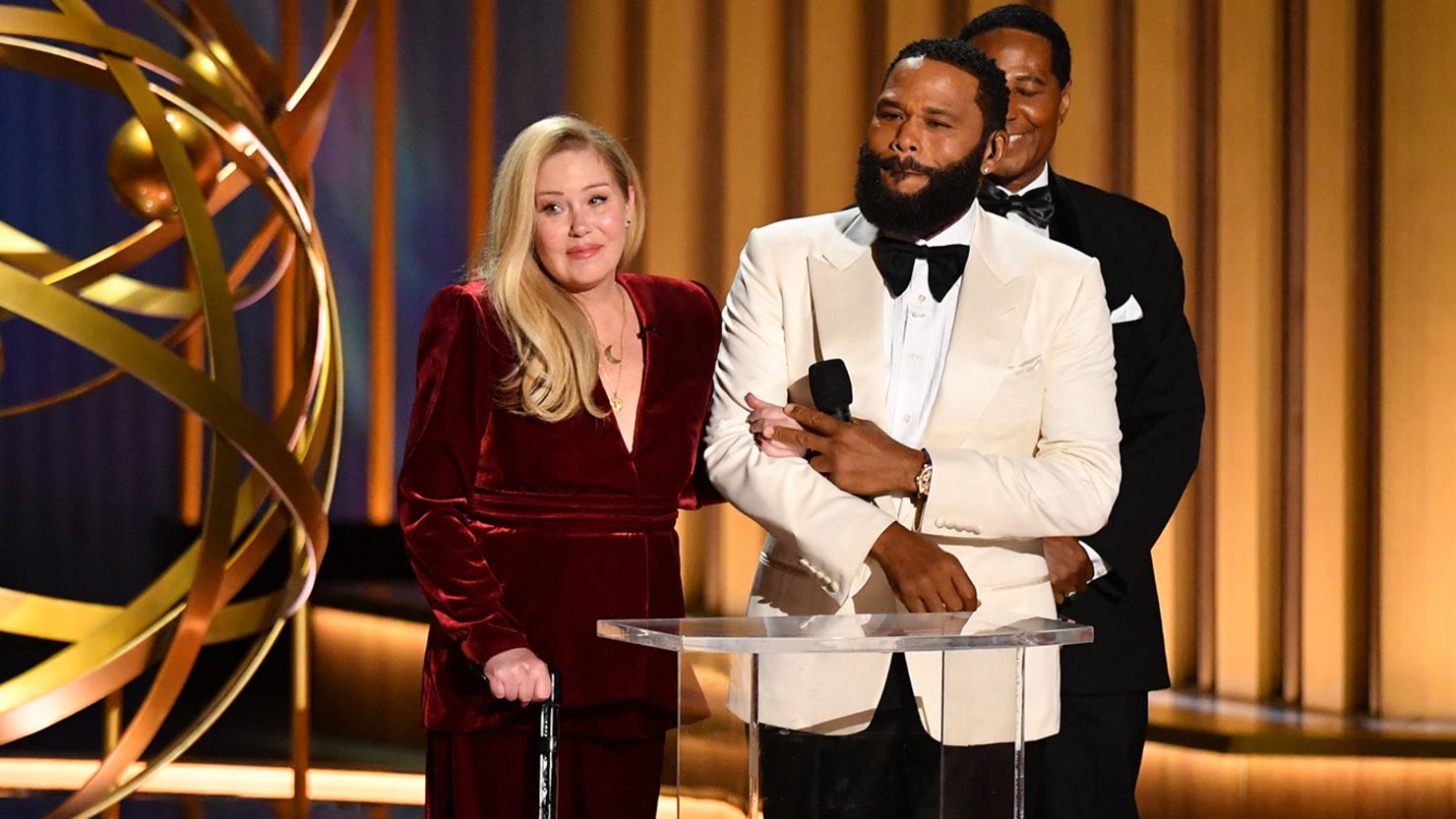 Actor Anthony Anderson and Christina Applegate speak onstage at the Emmy Awards.