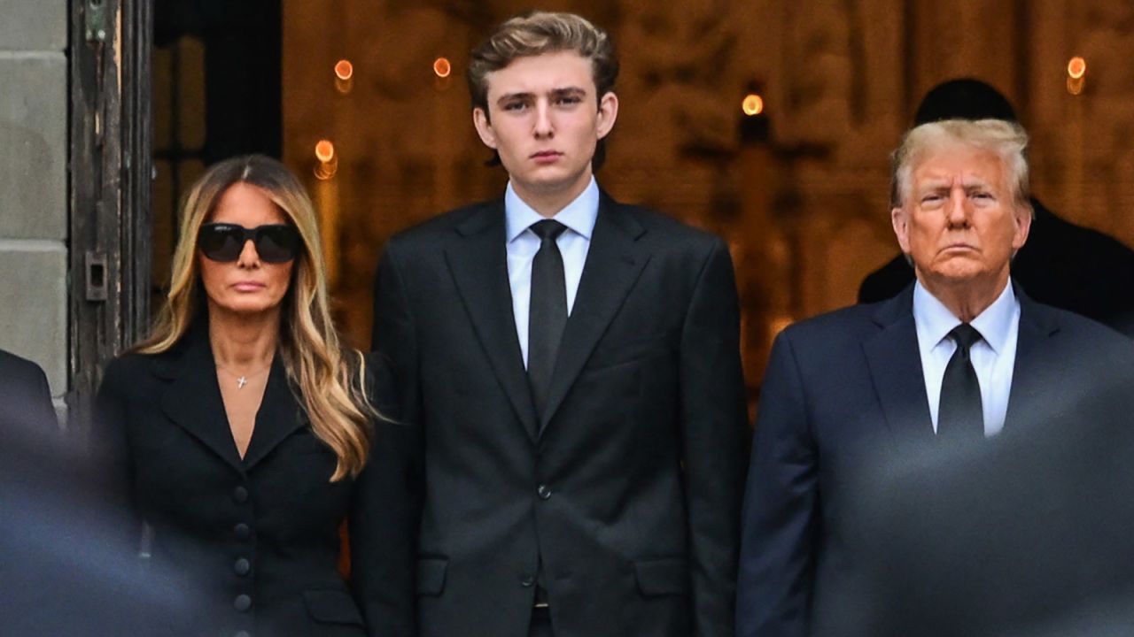 TOPSHOT - Former US President Donald Trump (center right) stands with his wife Melania Trump (center left) their son Barron Trump (center) and father-in-law Viktor Knavs (out of frame), as the coffin carrying the remains of Amalija Knavs, the former first lady's mother, is carried into the Church of Bethesda-by-the-Sea for her funeral, in Palm Beach, Florida, on January 18, 2024. Former first lady Melania Trump's mother Amalija Knavs, 78, died January 9, 2024 in Miami following an undisclosed illness. (Photo by GIORGIO VIERA / AFP) (Photo by GIORGIO VIERA/AFP via Getty Images)