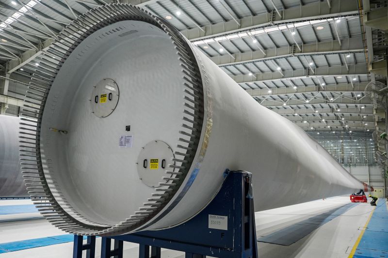 An employee working on a blade for a wind turbine produced at an Adani Group factory in the Indian city of Mundra.