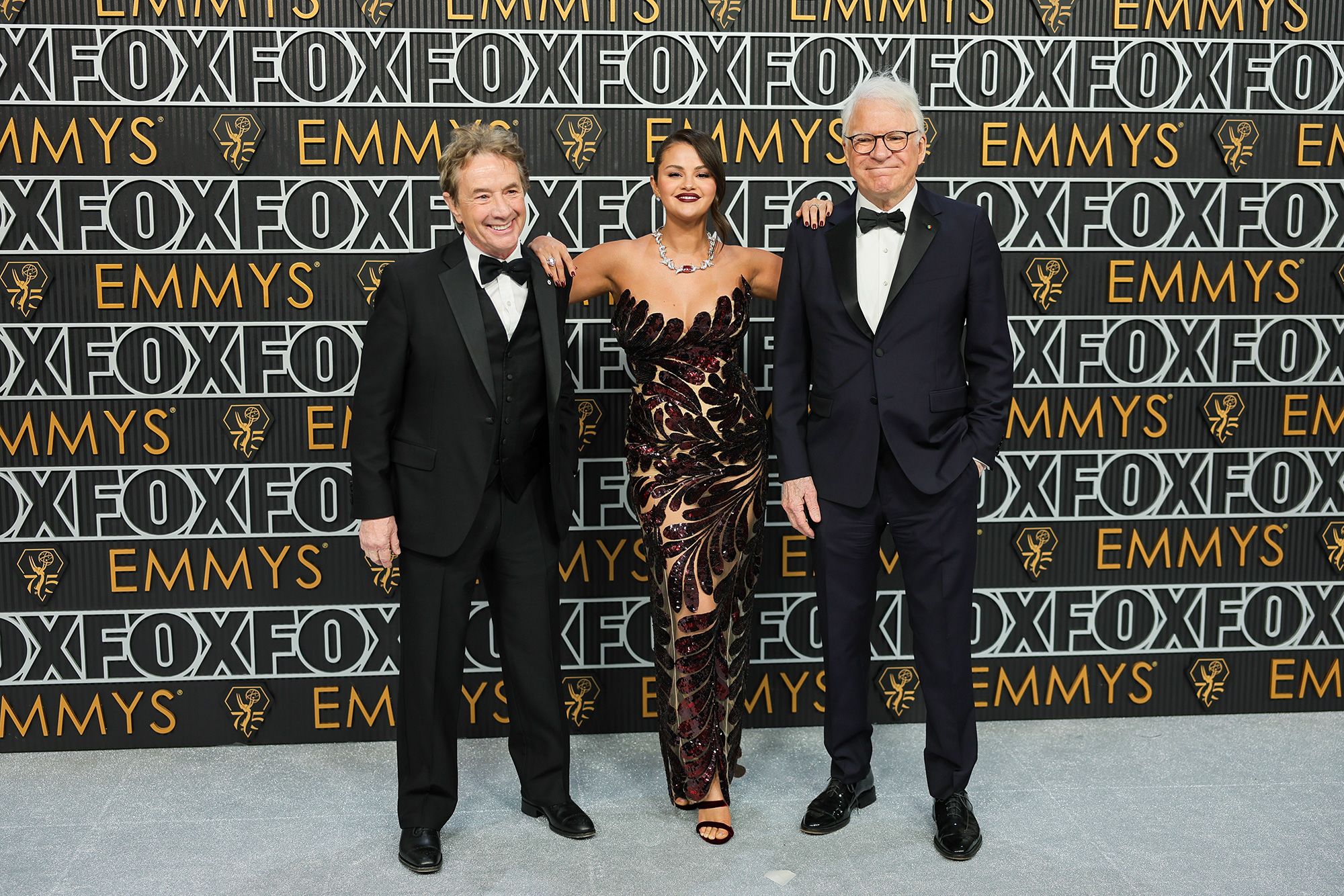 Martin Short and Steve Martin pose either side of their “Only Murders in the Building” co-star Selena Gomez, who wore Oscar de la Renta.