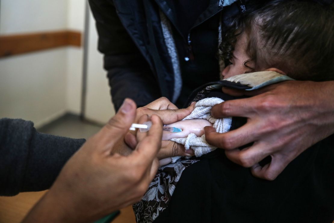 A UNRWA worker administers a polio vaccine at a clinic in Deir al-Balah in the central Gaza Strip on January 21, 2024.