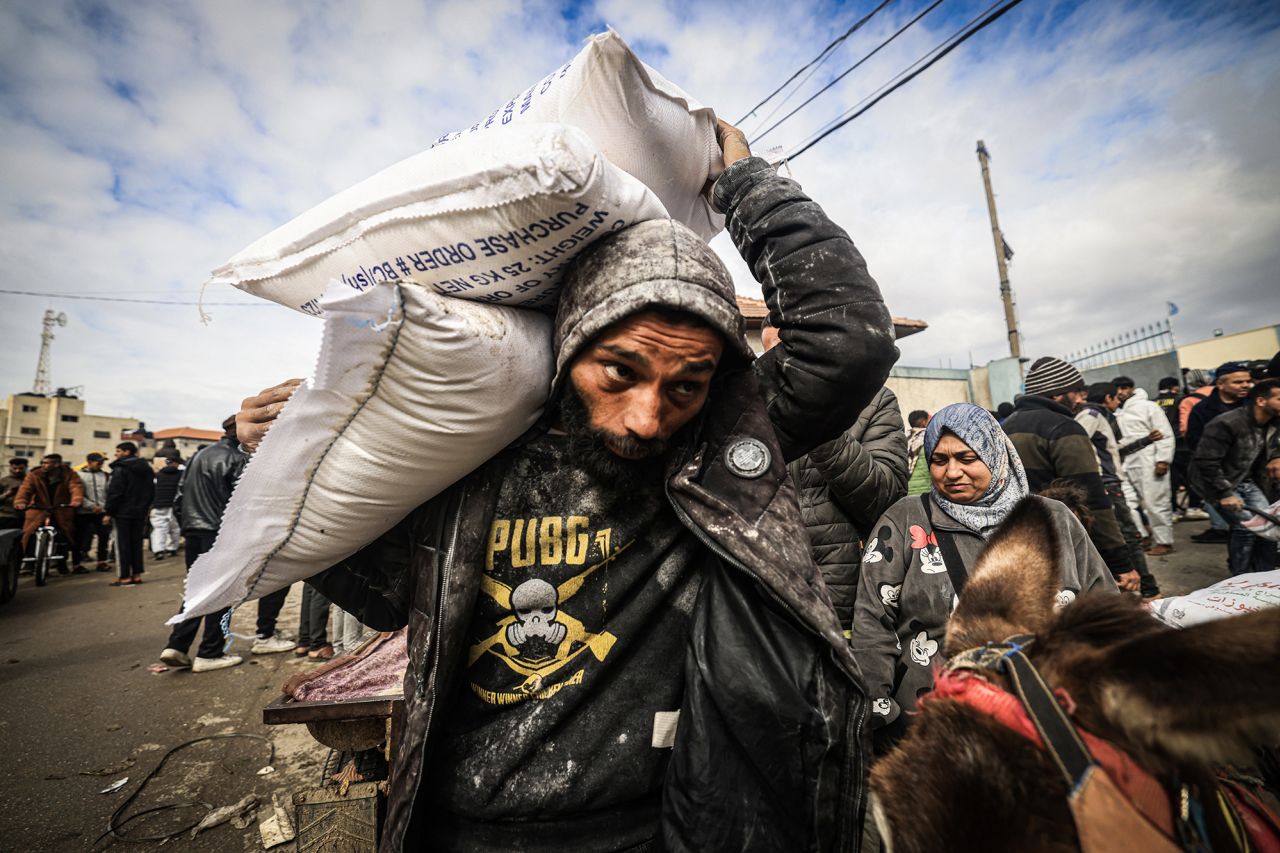 Displaced Palestinians receive food aid at the UNRWA center in Rafah, Gaza, in January 2024.