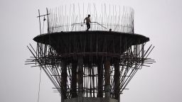 A construction worker carries metal rods during the construction of an elevated water tank in Ajmer on January 30, 2024.