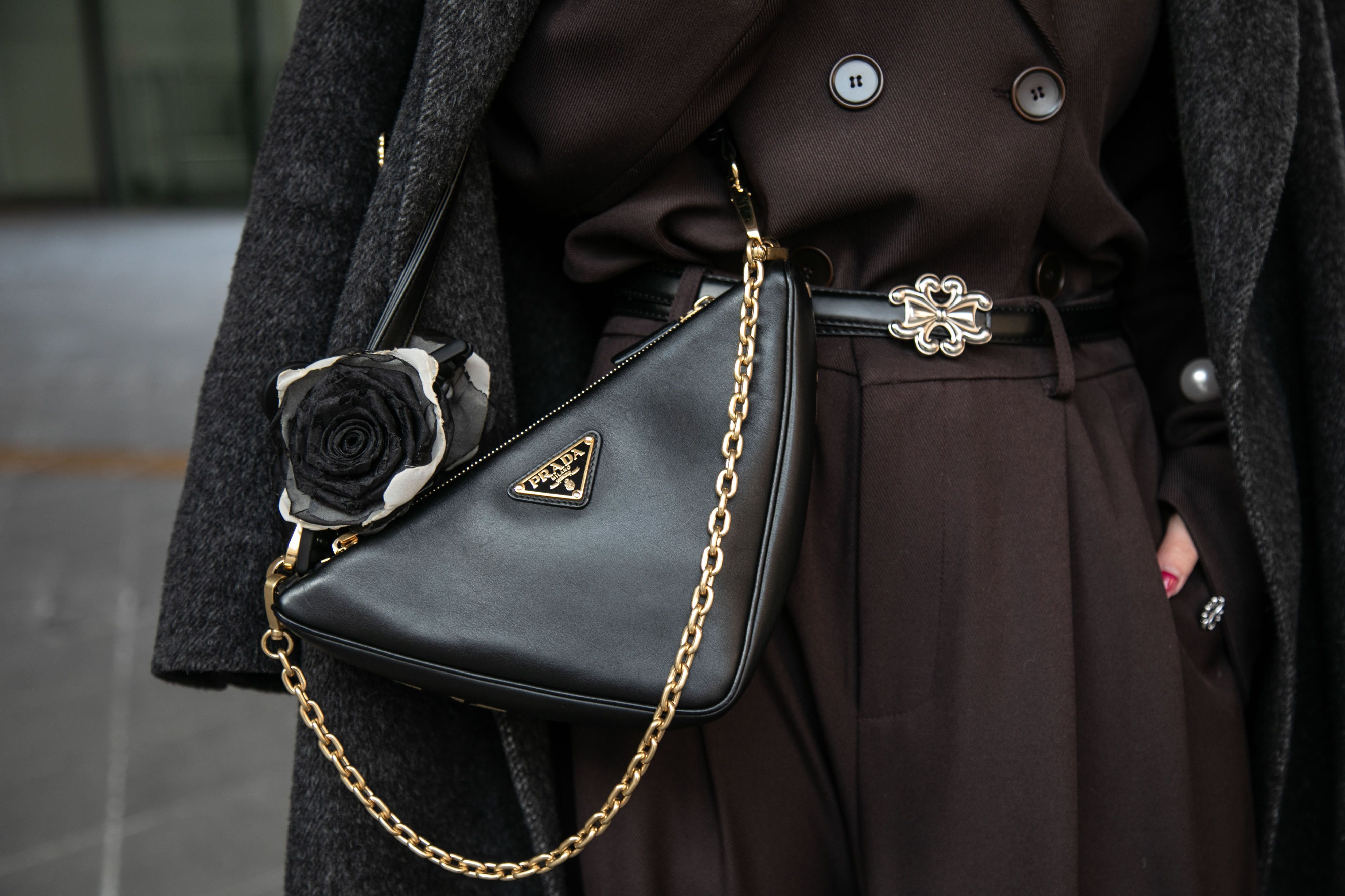 Wu Qin Qin wears a black Prada triangle bag over a black 4mile coat.