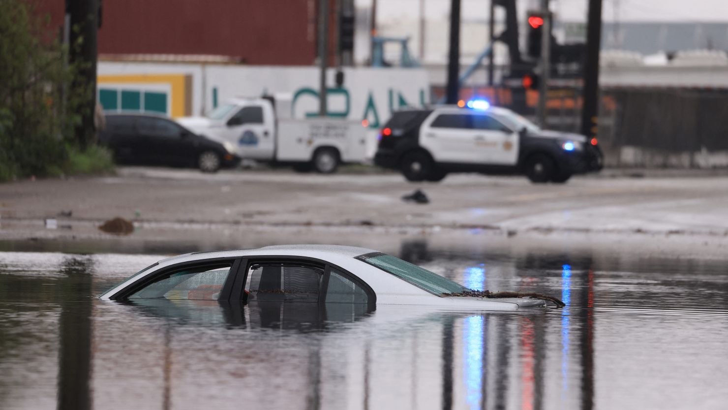A car sits partially submerged on a flooded road during a rain storm in Long Beach, California, on Thursday.