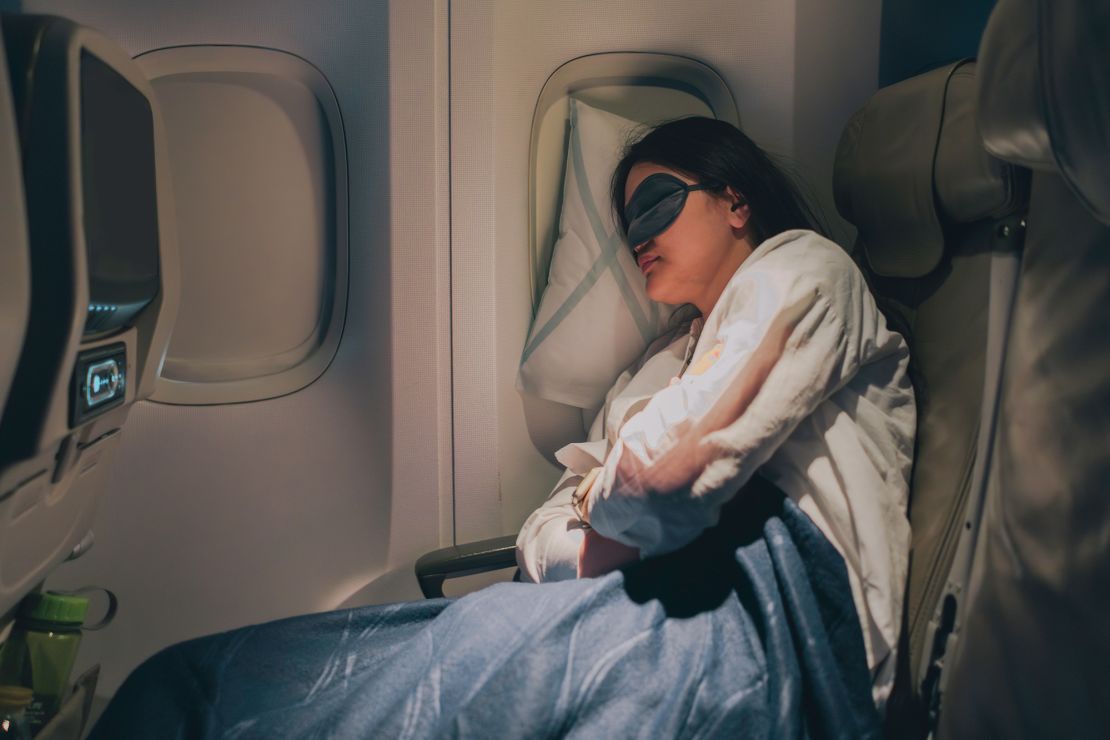 With her mask on to help her sleep, the woman gets good, deep sleep during her flight.