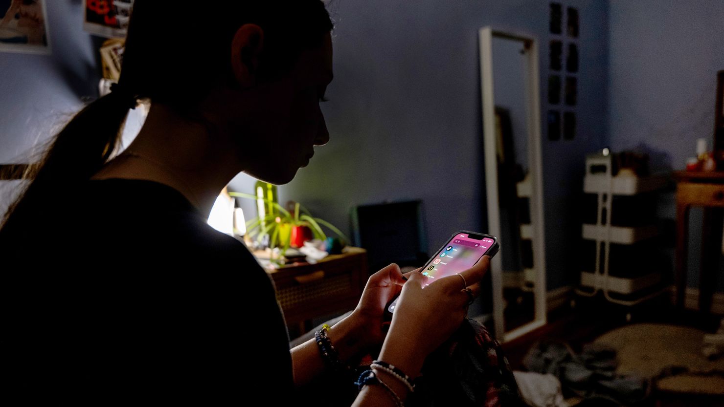 A teenager uses her mobile phone to access social media.