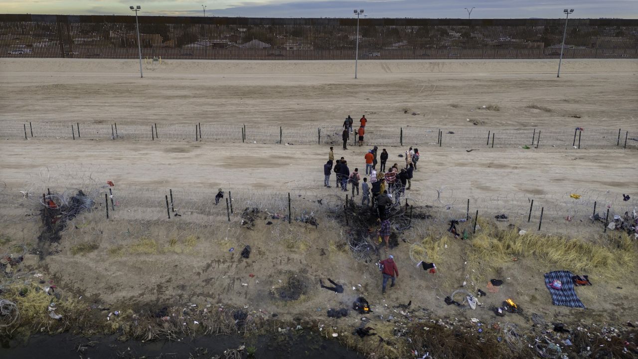 Migrants pass through razor wire after crossing the Rio Grande into El Paso, Texas, on February 1, 2024.