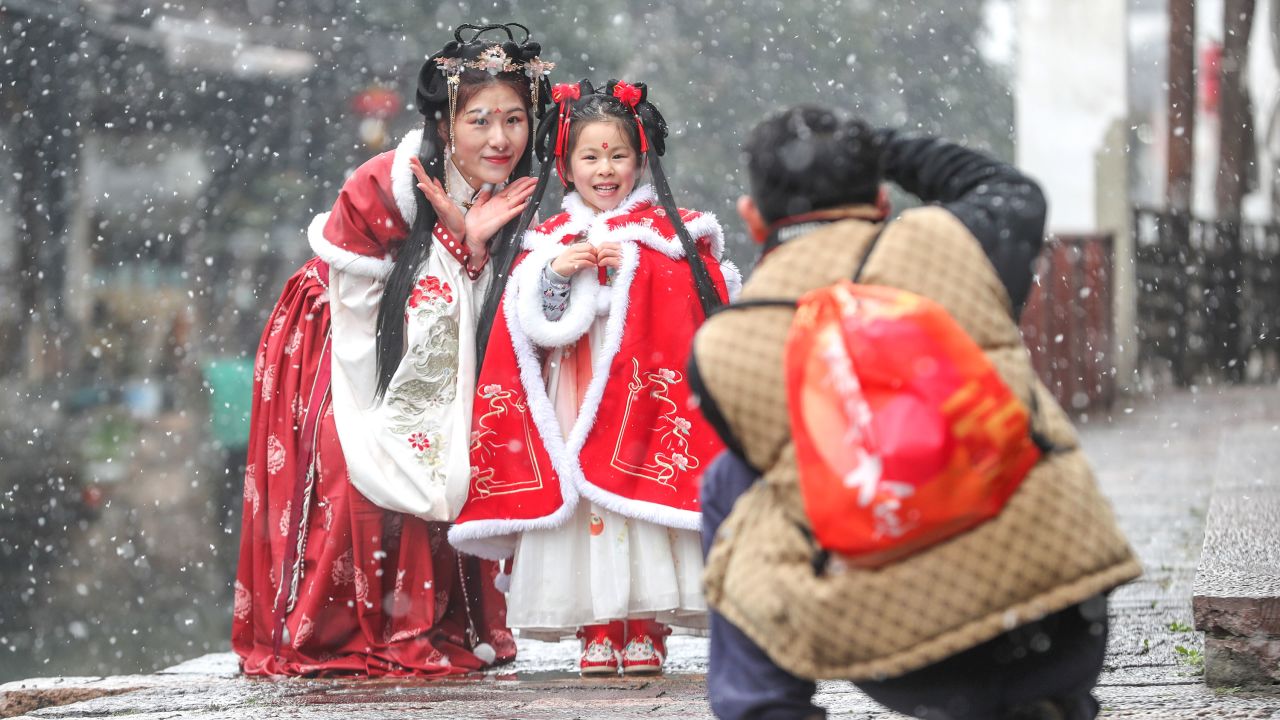 HUZHOU, CHINA - FEBRUARY 6, 2024 - Tourists wearing Hanfu enjoy the snow in Xinshi Ancient Town in Huzhou city, Zhejiang province, China, Feb 6, 2024. (Photo credit should read CFOTO/Future Publishing via Getty Images)
