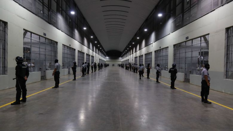 Agentes caminan afuera de las celdas del CECOT en Tecoluca el 6 de febrero de 2024 en San Vicente, El Salvador. En febrero de 2023, El Salvador inauguró la prisión más grande de Latinoamérica como parte del plan del presidente Nayib Bukele para luchar contra las pandillas.