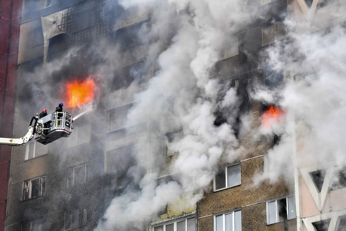 Ukrainian rescuers extinguish a fire in a residential building following a missile attack in Kyiv in February 2024.