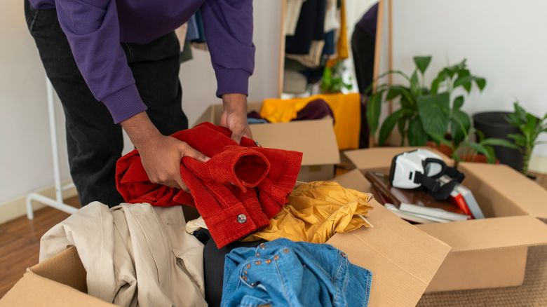 Man decluttering clothes at home
