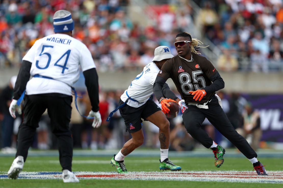 David Njoku runs with the ball while Bobby Wagner attempts to grab his flag.