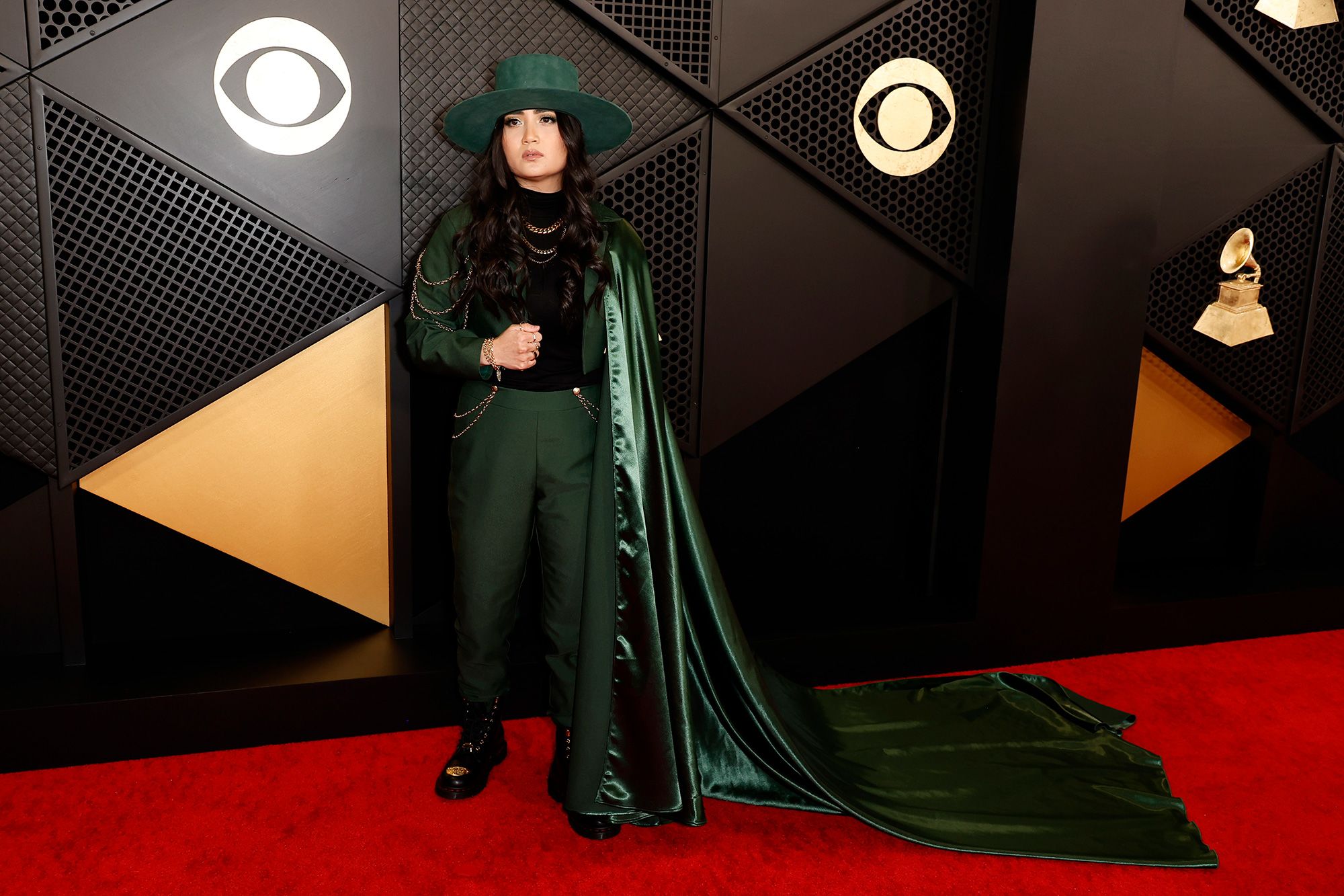 Emerging songwriter and producer Alex Ritchie gave her suit some added flair with a long flowing green cape, matching wide-brim hat and gold chains.