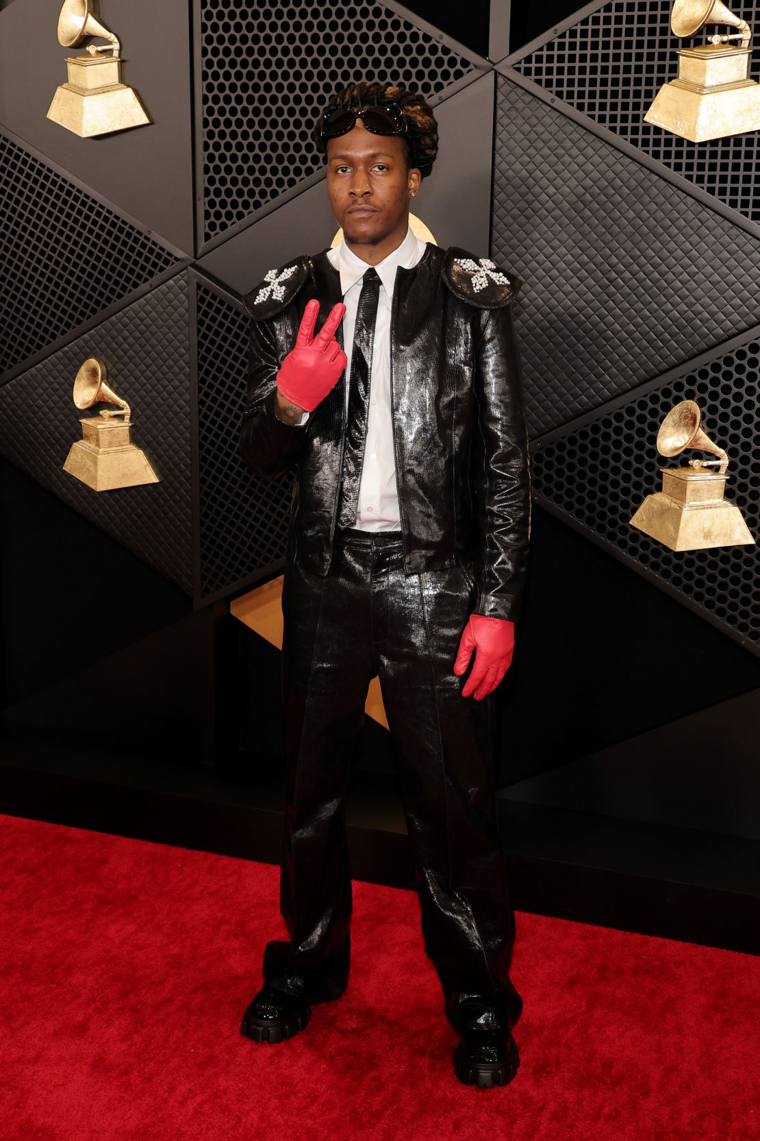 Musician ThankGod4Cody wore a shiny black two-piece suit with matching tie and bright red gloves.