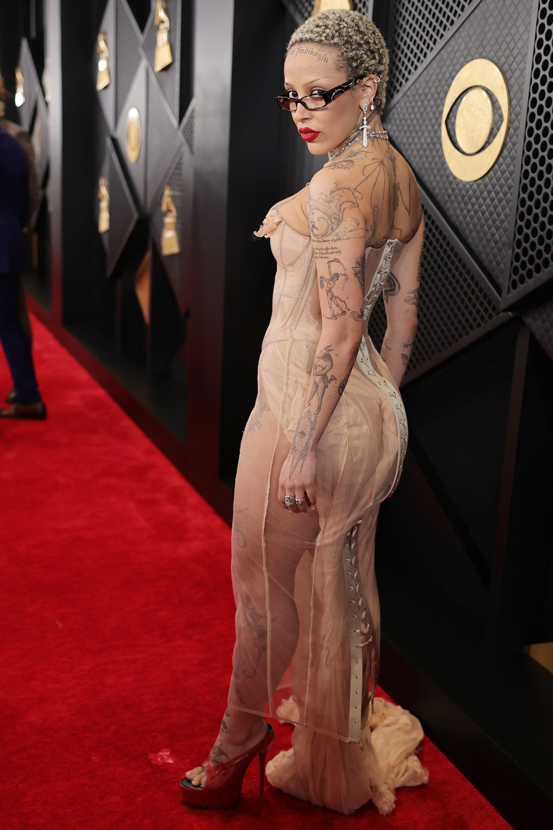 Doja Cat wore a structured barely-there sheer dress, by Turkish-British designer Dilara Findikoglu, and red peep-toe platform shoes.