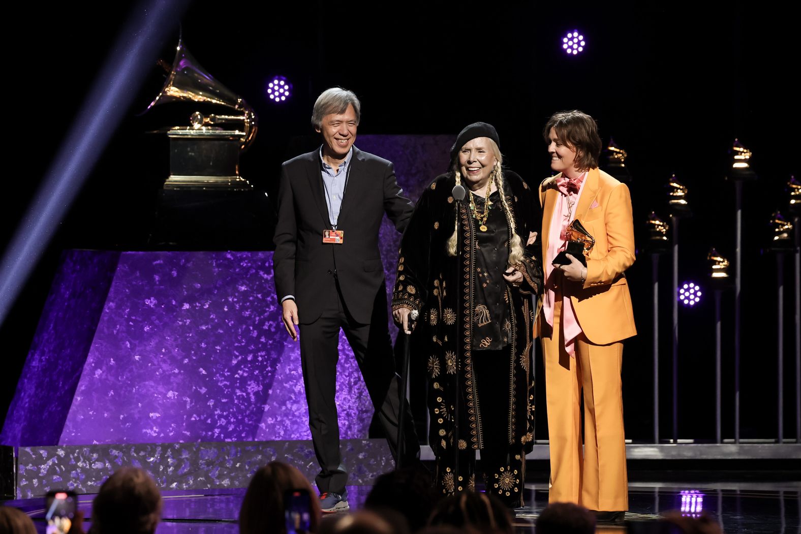 Mitchell, center, accepts the Grammy for best folk album ("Joni Mitchell at Newport") before the live show. It was Mitchell's 10th Grammy win. She also has a lifetime achievement award.
