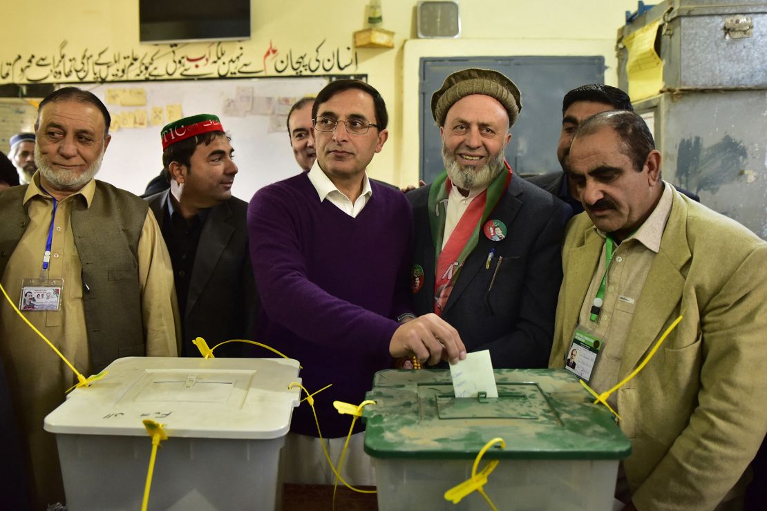 Pakistan Tehreek-e-Insaaf party's chairman Gohar Ali Khan (C) casts his ballot to vote at a polling station during Pakistan's national elections in Buner on February 8, 2024.