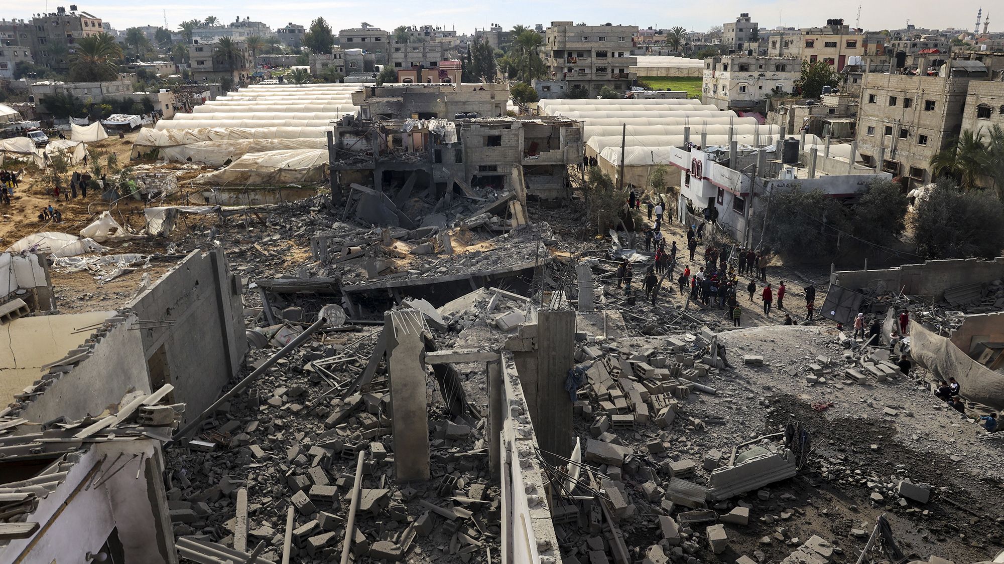 Palestinians inspect the damage amid the rubble of a building where two hostages were reportedly held before being rescued during an operation by Israeli security forces in Rafah, in the southern Gaza Strip, on February 12.