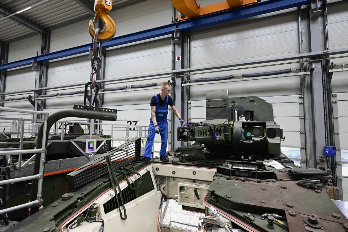 An employee works by a Puma fighting vehicle at a production line in February 2024 in Lower Saxony, Germany.