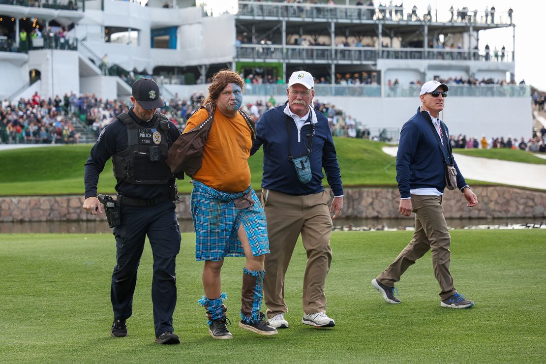 Police and staff apprehend a fan dressed as William Wallace from "Braveheart" after he ran onto the 11th hole during the second round.