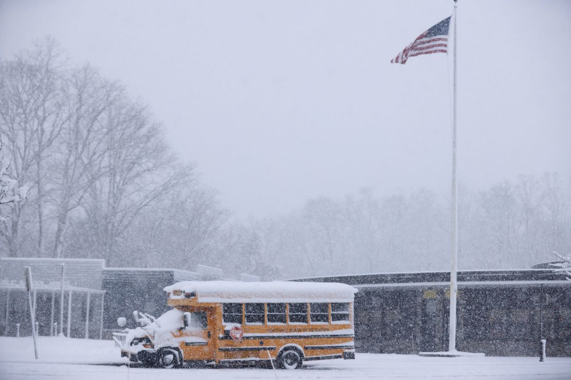 A school bus is covered in snow at the Northvale Public School in Northvale, New Jersey.