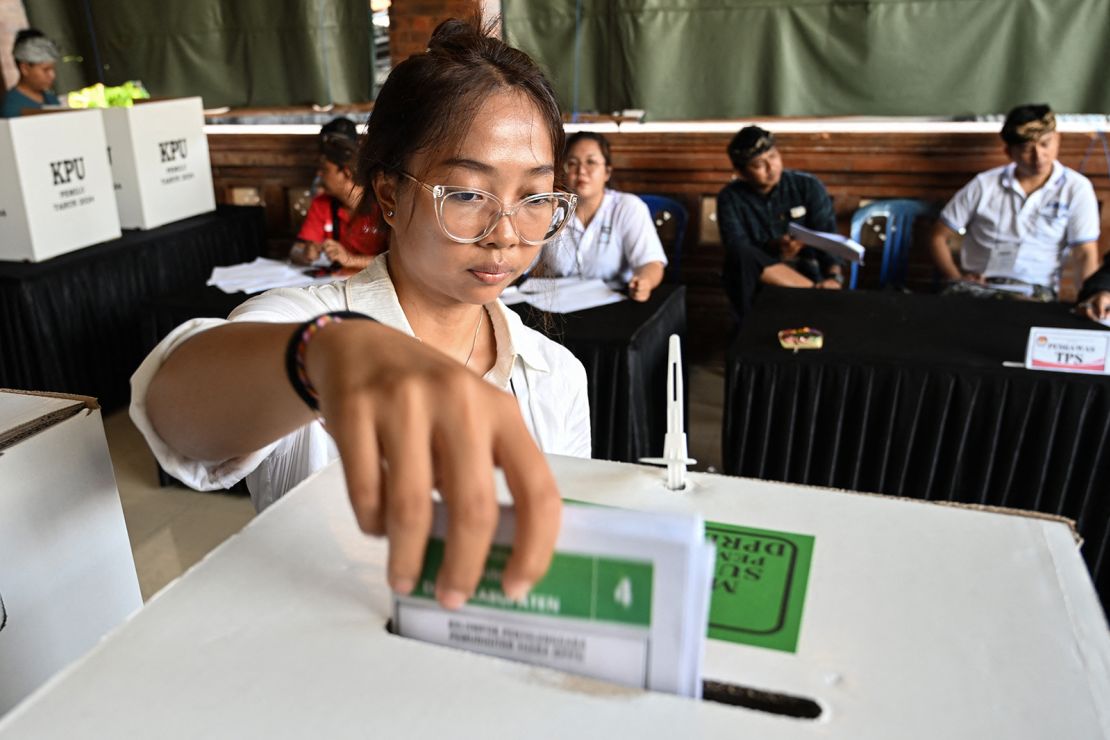 A woman casts her ballot in Banjar Teba, Jimbaran on the resort island of Bali on February 14, 2024.