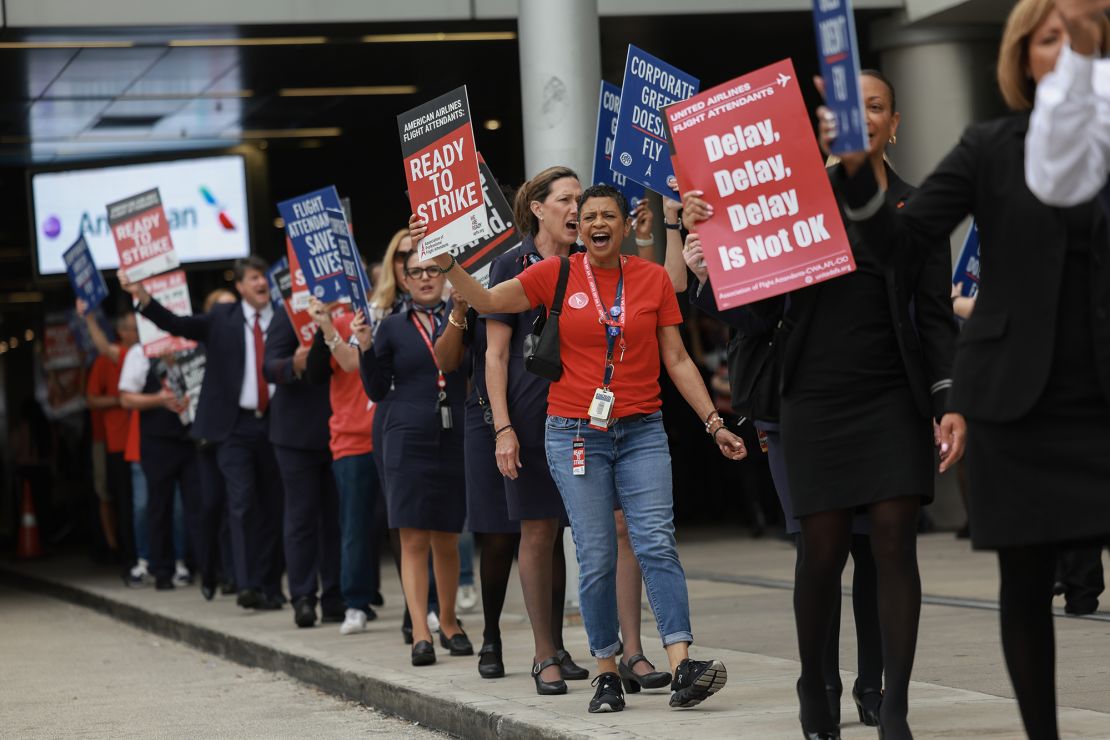 Flight attendants from both American and United Airlines picket at Miami International Airport Tuesday.