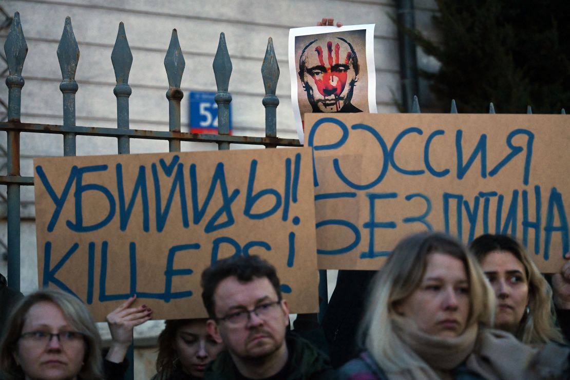 Demonstrators hold placards reading 'Killers' and 'Russia without Putin' during a rally in front of the Russian embassy in Warsaw on February 16 following the announcement that Alexey Navalny had died. (Photo by Sergei GAPON / AFP) (Photo by SERGEI GAPON/AFP via Getty Images)