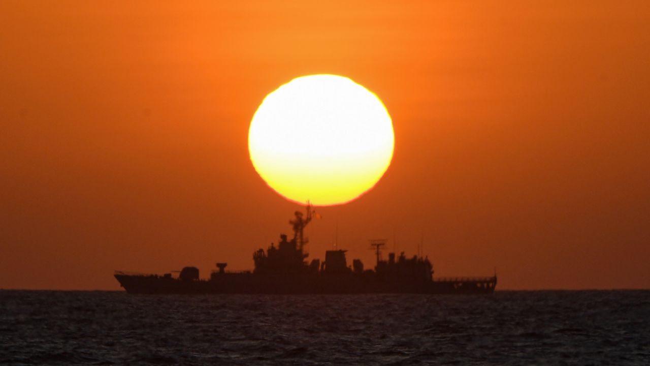 This photo taken on February 15, 2024 shows a Chinese navy ship during sunrise near the China-controlled Scarborough Shoal, in disputed waters of the South China Sea. The Philippines on February 17 accused Chinese coast guard vessels of "dangerous" manoeuvres for attempting to block a Filipino vessel dropping supplies to fishermen at a reef off the Southeast Asian nation's coast. (Photo by Ted ALJIBE / AFP) / âThe erroneous mention[s] appearing in the metadata of this photo by Ted ALJIBE has been modified in AFP systems in the following manner: [At sea] instead of [Scarborough Shoal]. Please immediately remove the erroneous mention[s] from all your online services and delete it (them) from your servers. If you have been authorized by AFP to distribute it (them) to third parties, please ensure that the same actions are carried out by them. Failure to promptly comply with these instructions will entail liability on your part for any continued or post notification usage. Therefore we thank you very much for all your attention and prompt action. We are sorry for the inconvenience this notification may cause and remain at your disposal for any further information you may require.â