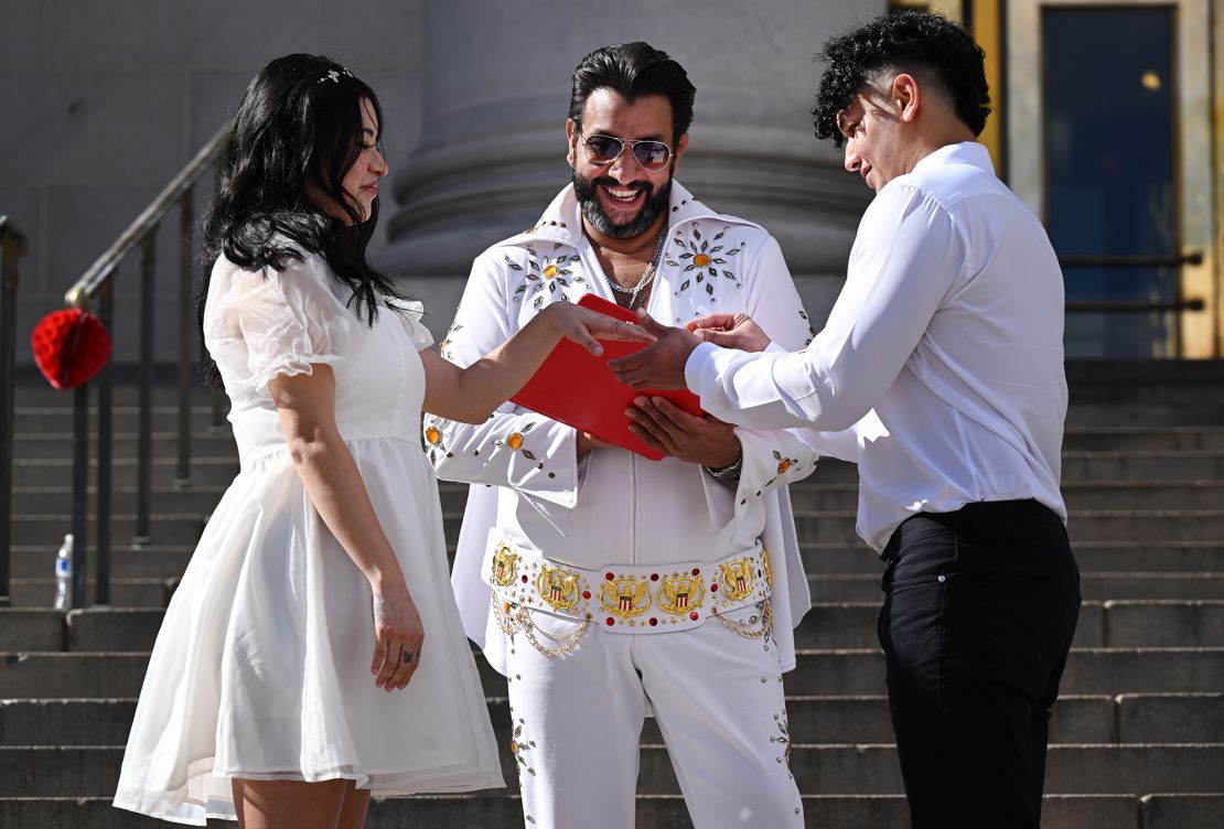 Osama Zayed puts a ring on his new wife Ingrid during the 16th Annual Burning Love Marriage Marathon on the steps of the City and County Building in Denver, Colorado on February 14, 2024.