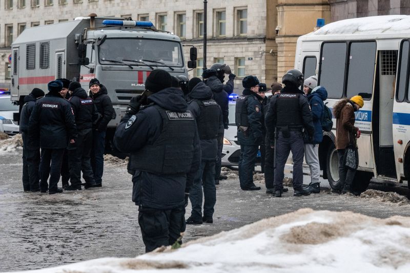 Police detain people after laying flowers at a monument to victims of political repression on Saturday.