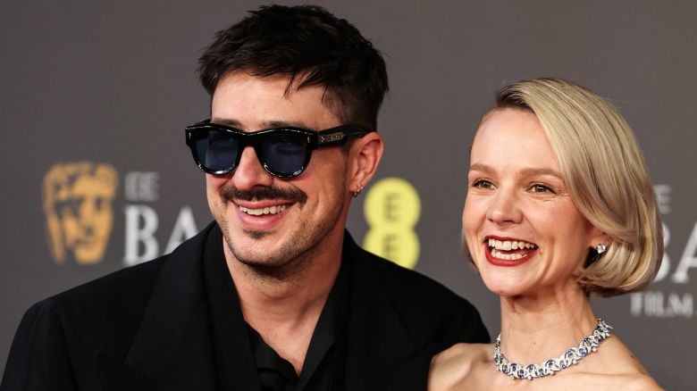 British actress Carey Mulligan (R) poses with her Husband US singer and musician Marcus Mumford poses on the red carpet upon arrival at the BAFTA British Academy Film Awards at the Royal Festival Hall, Southbank Centre, in London, on February 18, 2024.