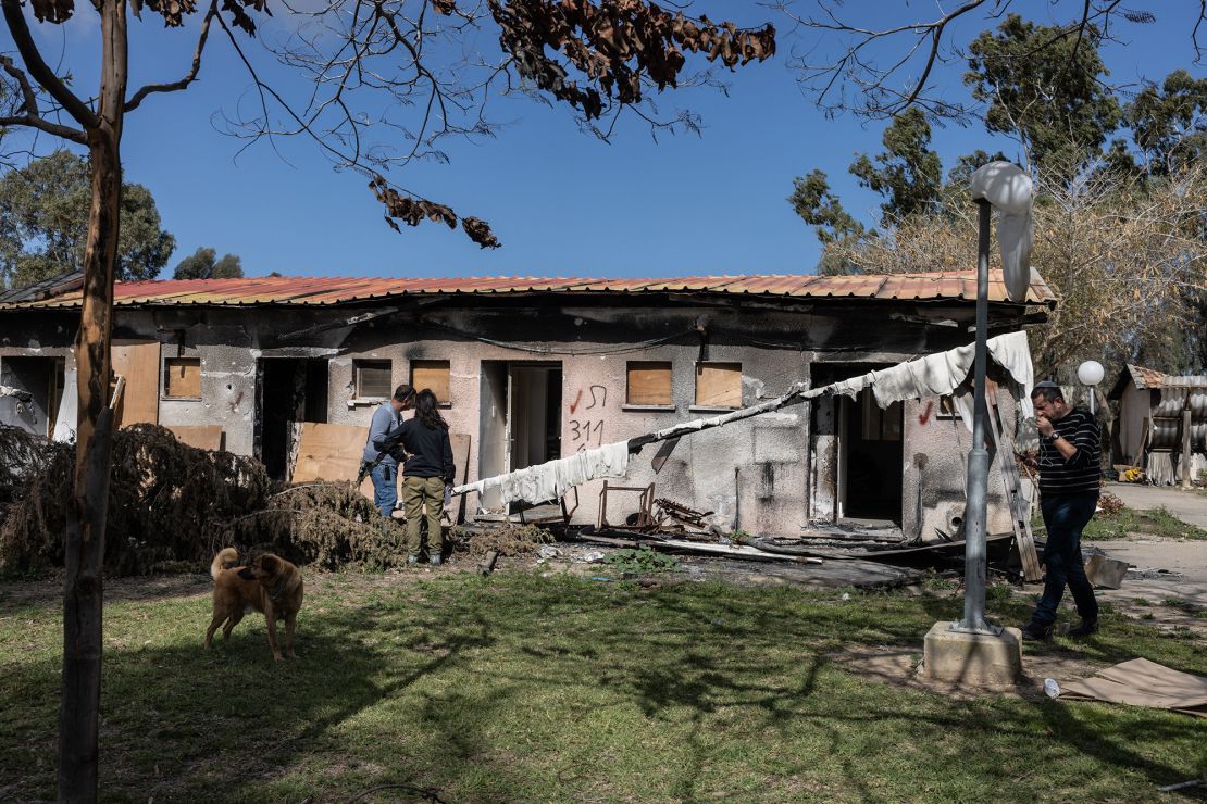 People examine the damage inflicted on their community in kibbutz Nirim after the October 7, 2023 attacks.