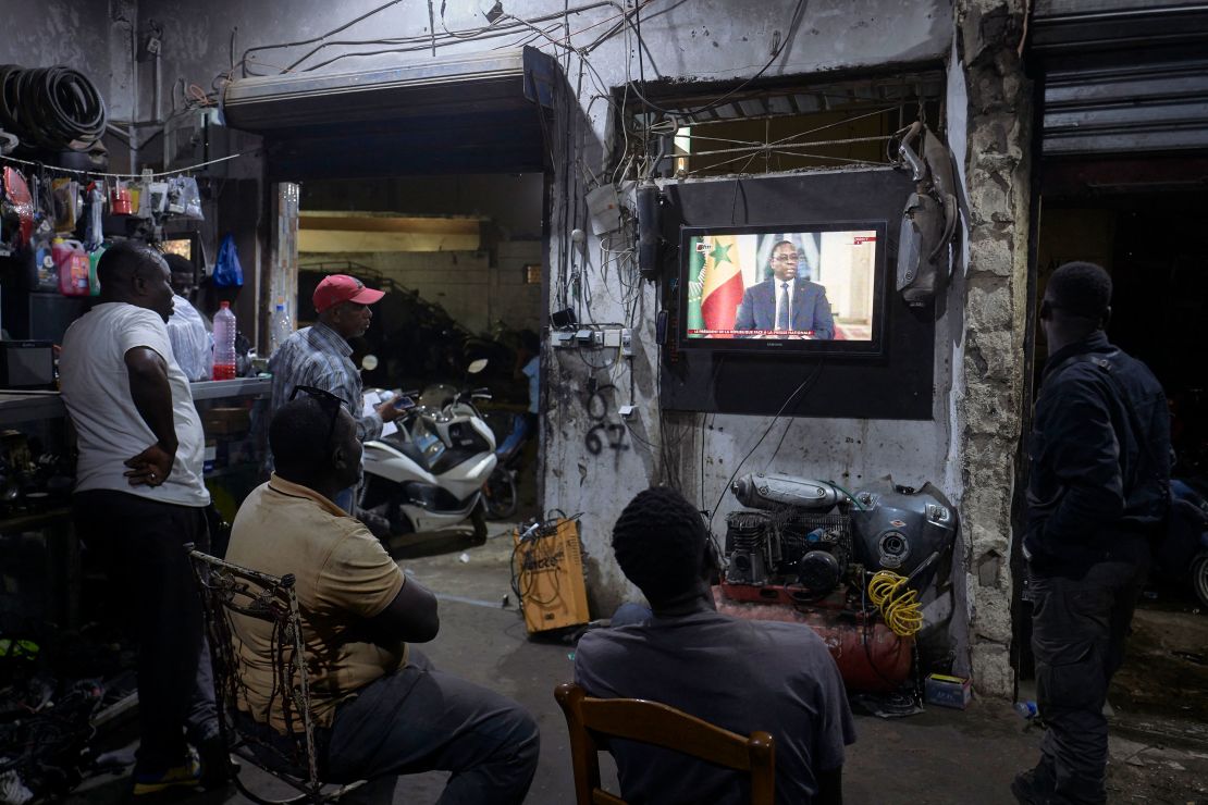 People watch the Senegal's President Macky Sall during a live press conference broadcast on the national television, in the district of Medina in Dakar on February 22, 2024.