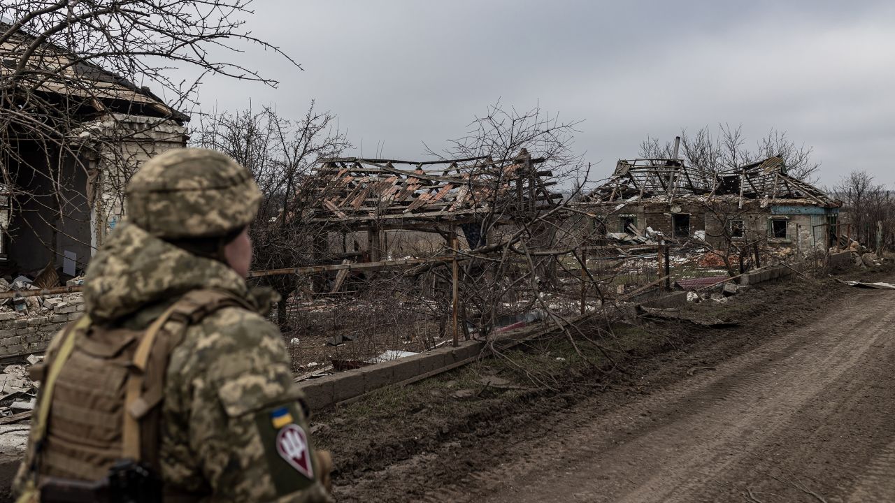 Ukrainian soldier walks near a house destroyed by Russian shelling on February 23.