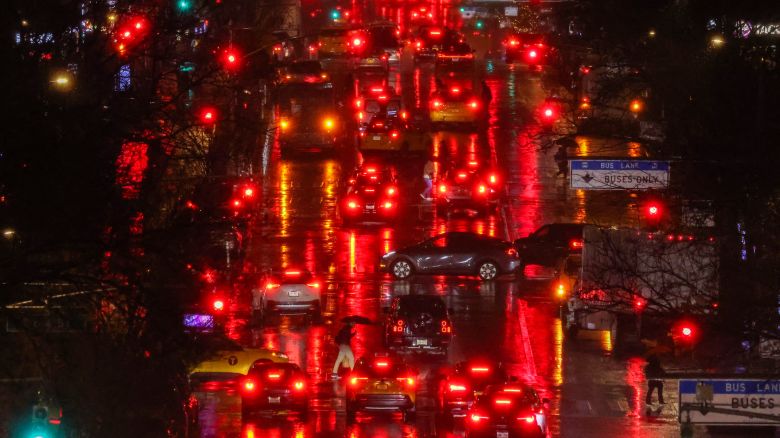 Pedestrians and cars move along First Avenue in the Manhattan borough of New York, in the pouring rain, on February 27, 2024. (Photo by Charly TRIBALLEAU / AFP)