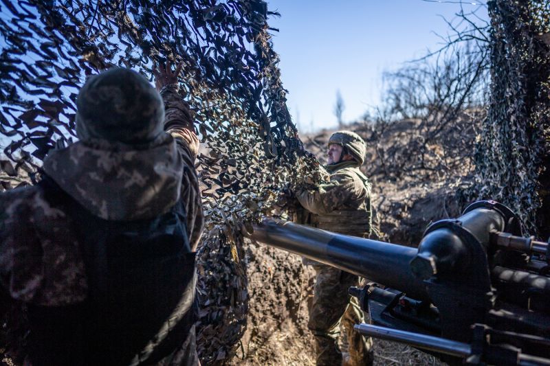 Ukrainian servicemen of 79th brigade cover a 105 mm howitzer with a camouflaged net near the frontline outside of Marinka as the war between Russia and Ukraine continues in Donetsk Oblast, Ukraine on February 28, 2024.