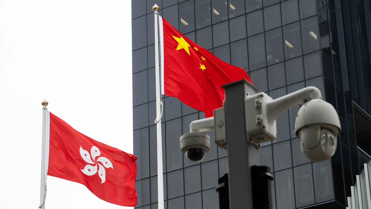 Security cameras, as well as the Chinese and Hong Kong flags, are seen in Hong Kong on February 28, 2024.