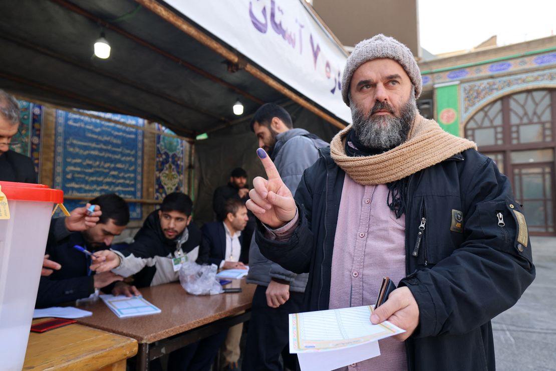 An Iranian man shows his ink-stained finger after casting her ballot, during elections to select members of parliament and the Assembly of Experts, in Tehran on Friday.