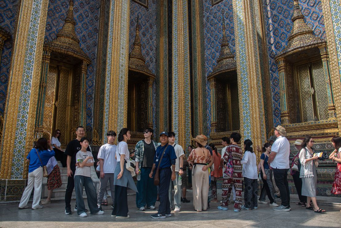 Chinese tourists visit the Temple of the Emerald Buddha in Bangkok.