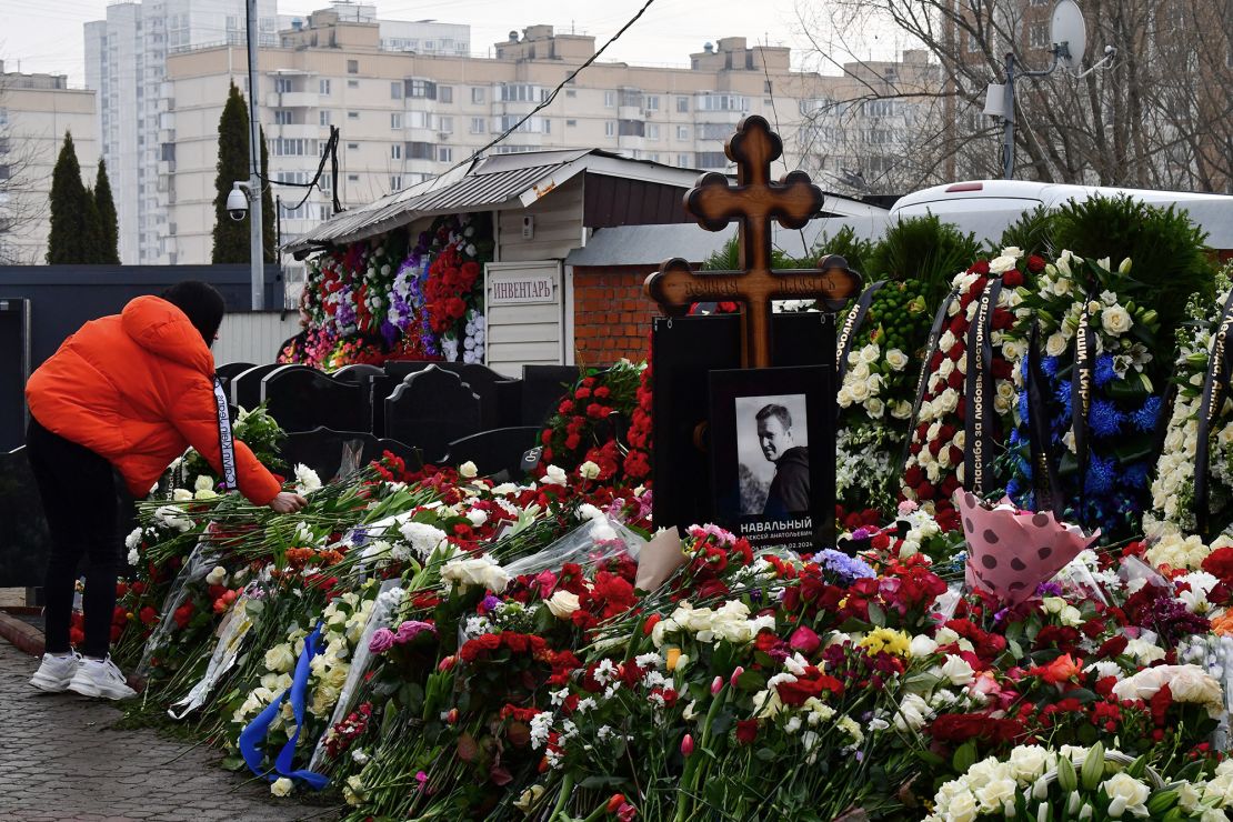 A mourner lays flowers on the grave of Russian opposition leader Alexey Navalny at the Borisovo cemetery in Moscow on March 2, 2024, the day after Navalny's funeral.