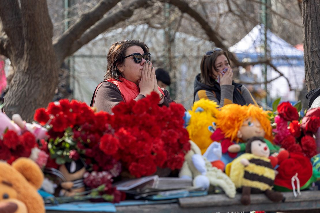 People visit the remnants of the building that was struck by a Russian drone in Odesa, leaving flowers and toys at the site of the attack that killed 12 people.