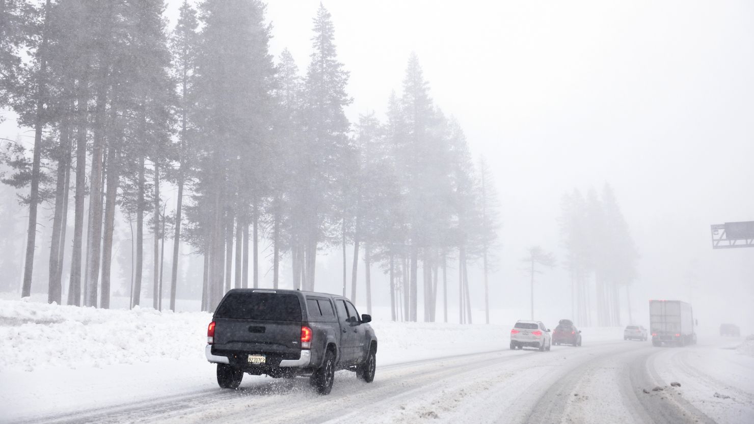Vehicles drive as snow falls along I-80 in the Sierra Nevada mountains on February 29, 2024 near Kingvale, California.