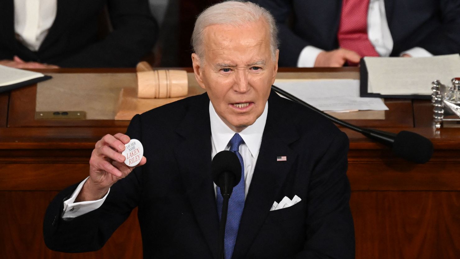 President Joe Biden holds a Laken Riley button while delivering the State of the Union address at the Capitol in Washington, DC, on March 7.