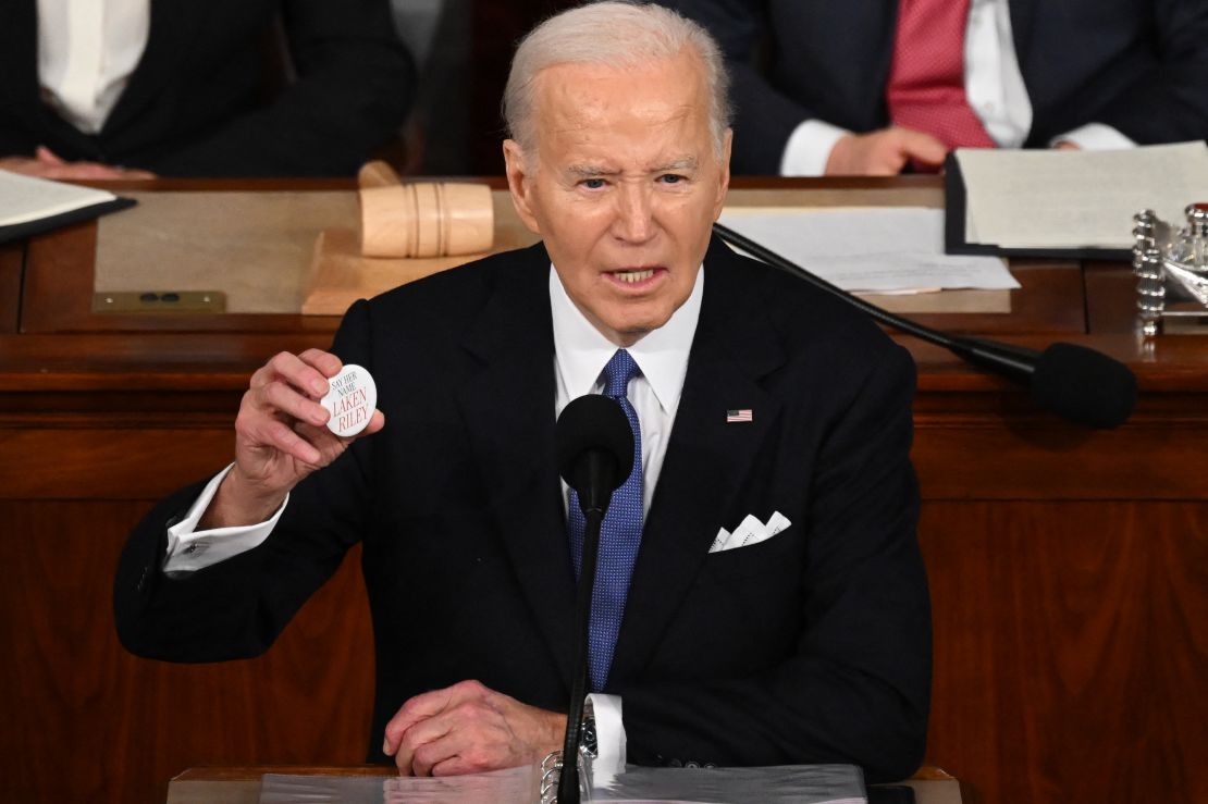 President Joe Biden holds a "Say her name Laken Riley" button while delivering the State of the Union address in the House Chamber of the US Capitol in Washington, DC, on March 7.