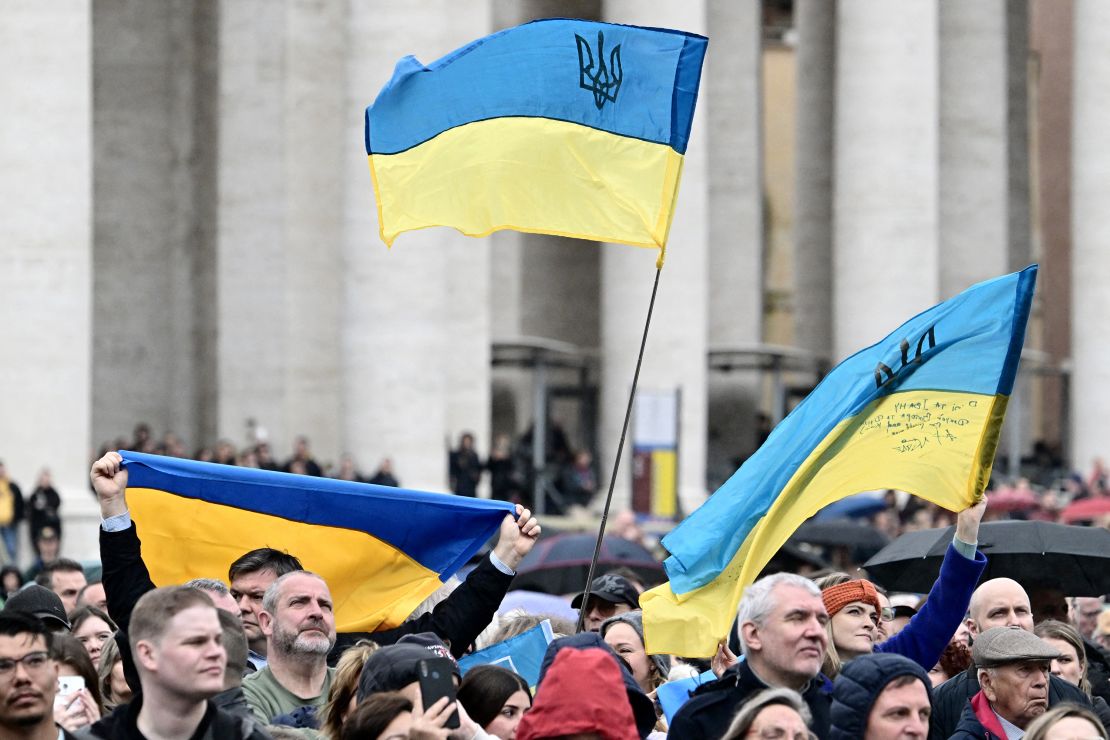 People wave Ukrainian flags at St.Peter's square as Pope Francis addresses the crowd on Sunday.